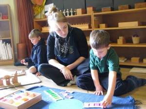 teacher sat on floor with pupils